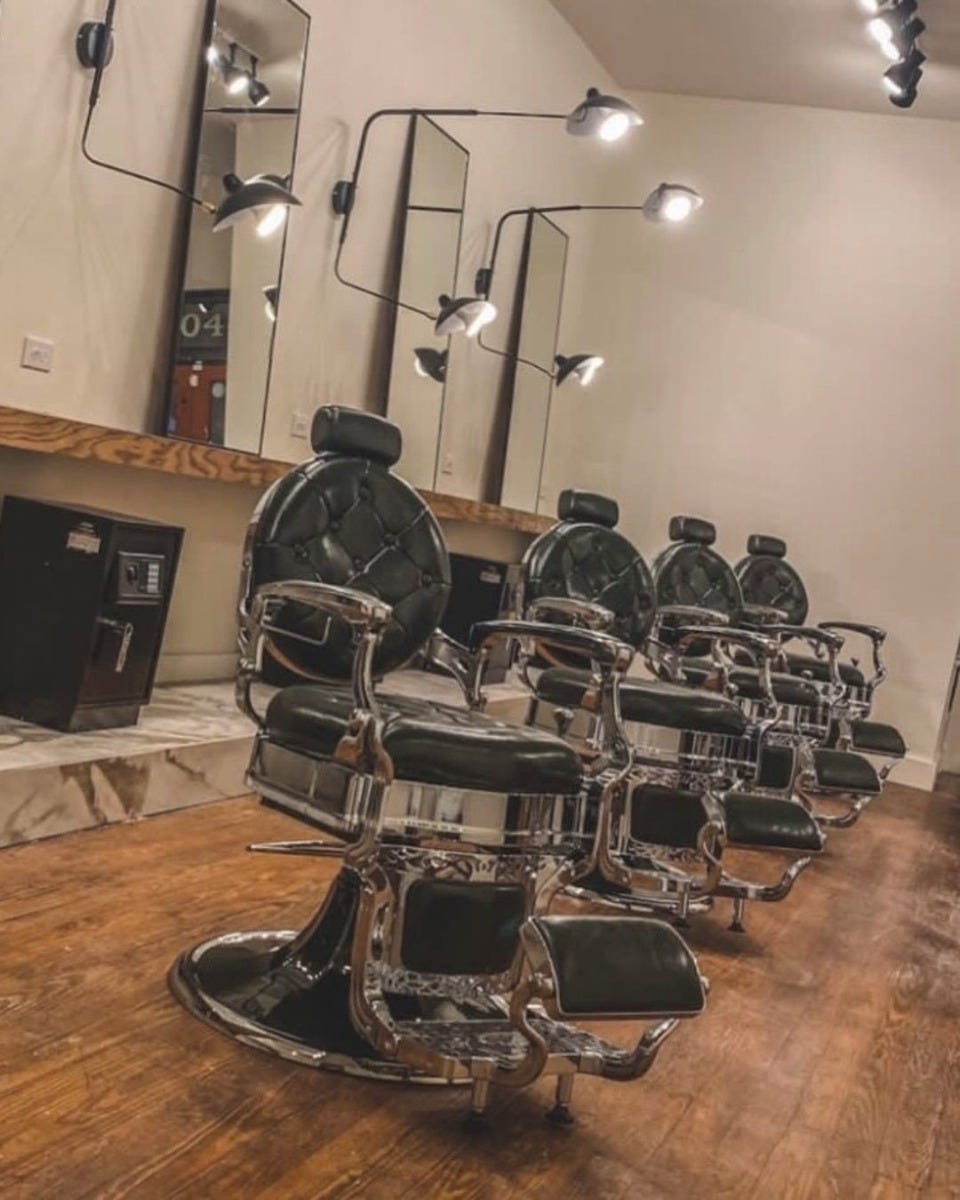 four barber chairs in a small modern barber shop with proper spacing between each chair