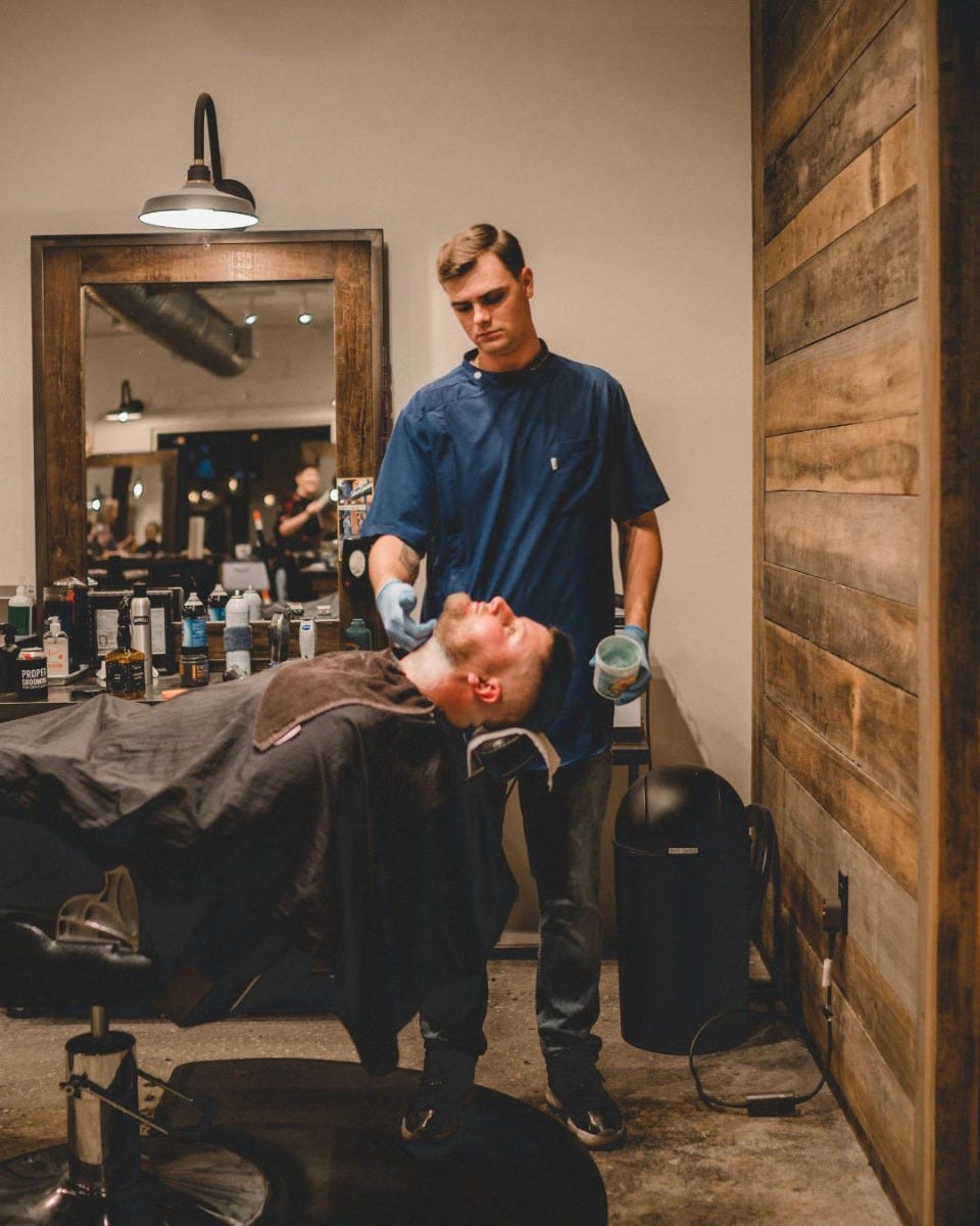 man getting a shave in a fully-reclined barber chair