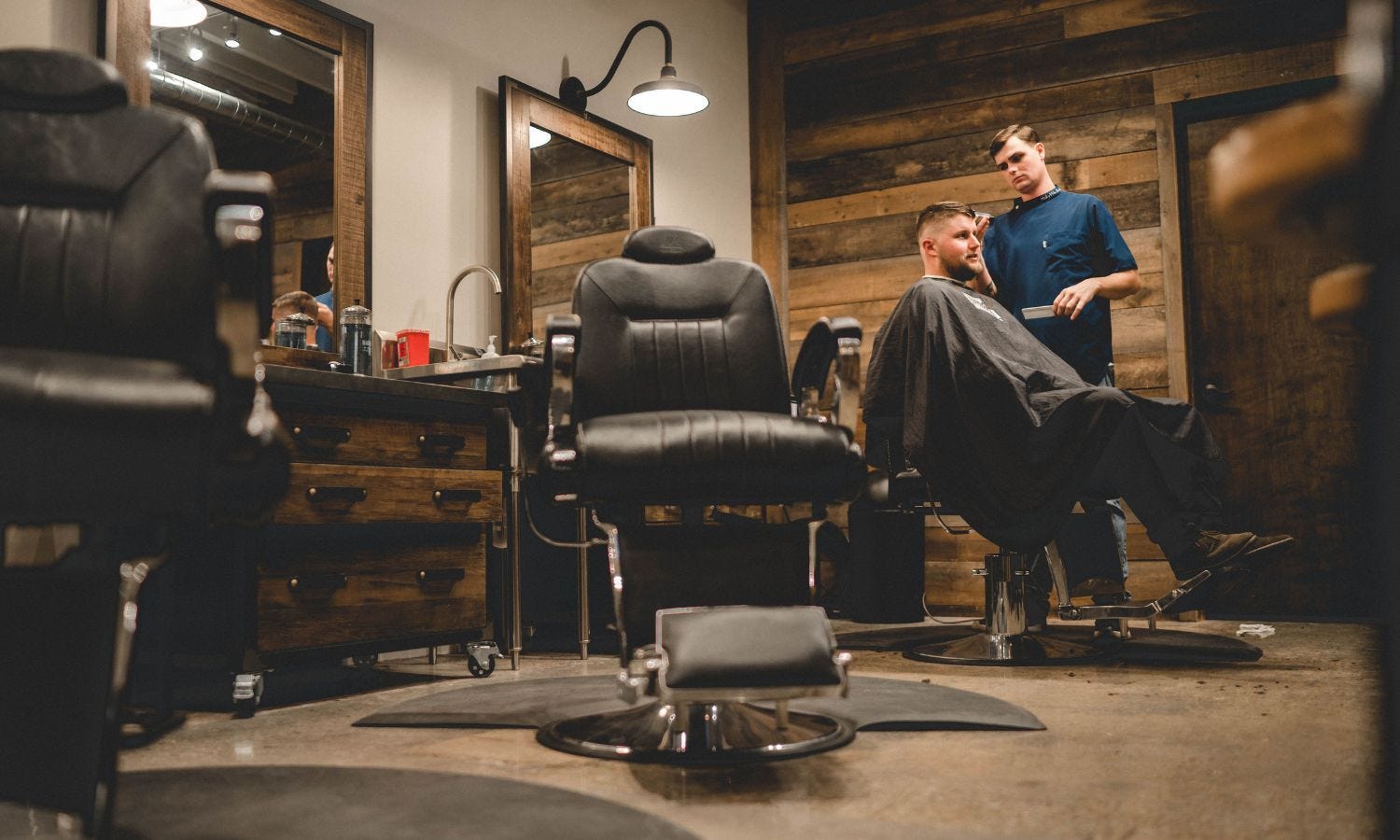 low-angle view of a barber shop with three barber chairs with footrests
