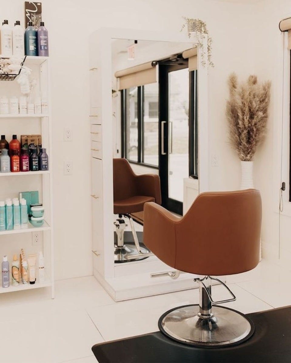 single-sided styling station with full-length mirror & built-in storage in a small, minimalist hair salon