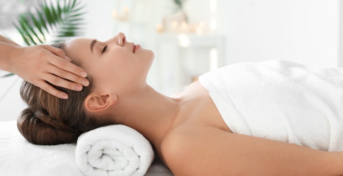 woman receiving temple massage in zen-like massage room